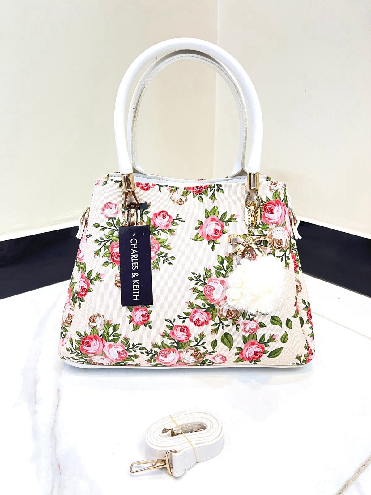 Elegant Floral Pattern Handbag with Stylish Handle and Charm Accent