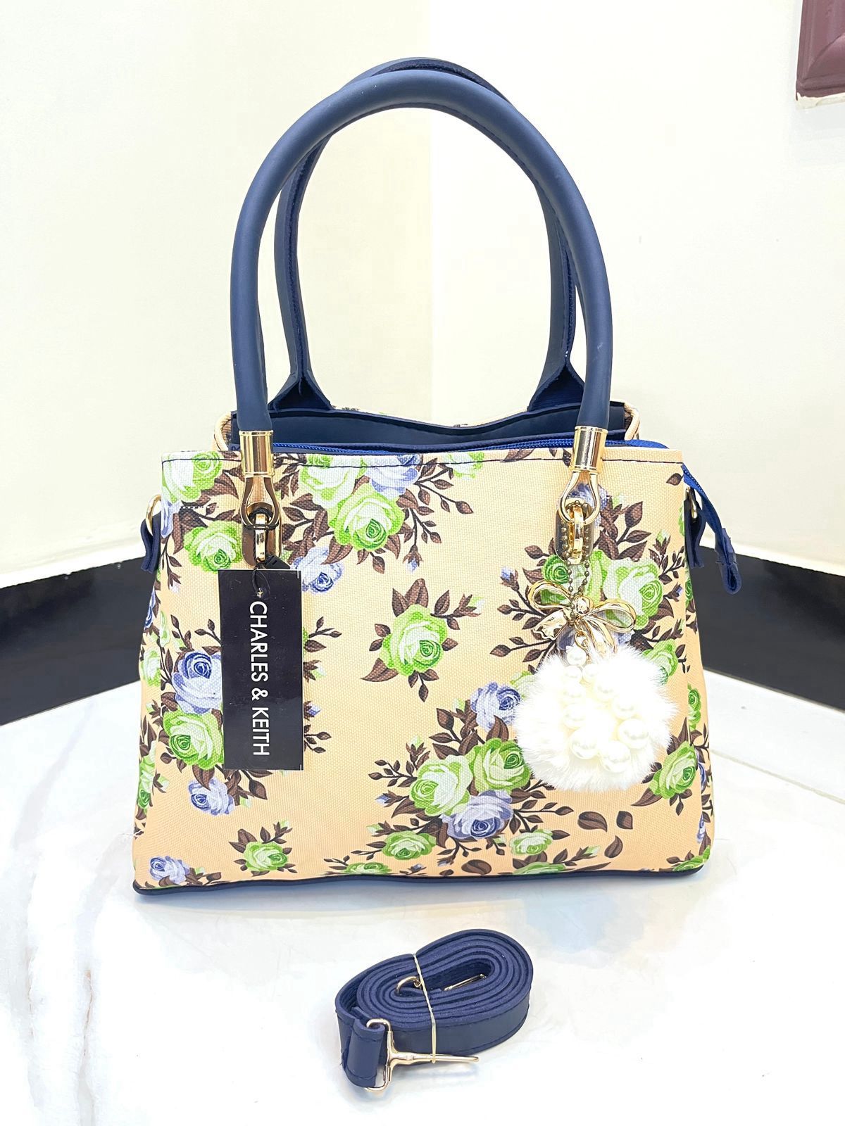 Elegant Floral Pattern Handbag with Stylish Handle and Charm Accent